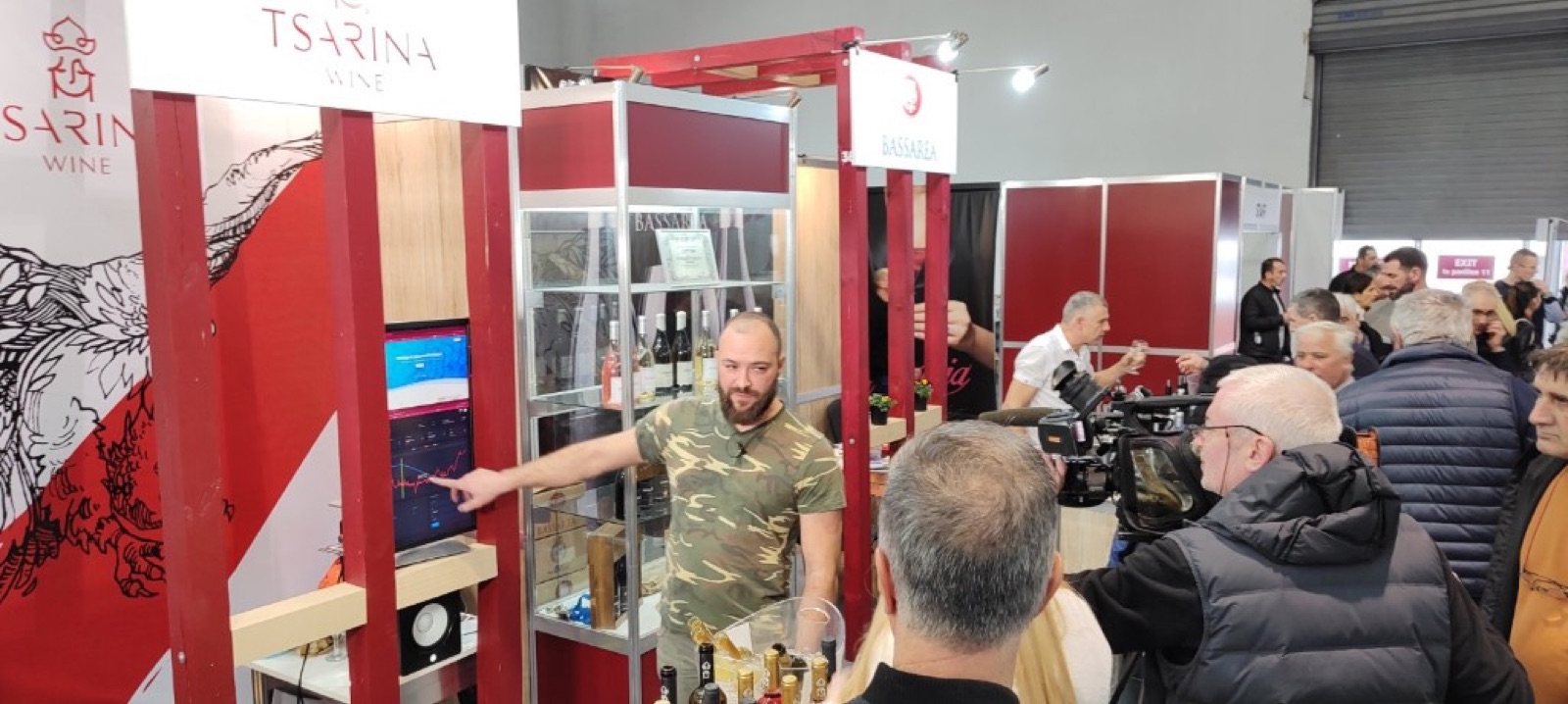 Expo stand of Tsarina Wine with the SCEPTER dashboard live on screen, visitors and a TV camera filming