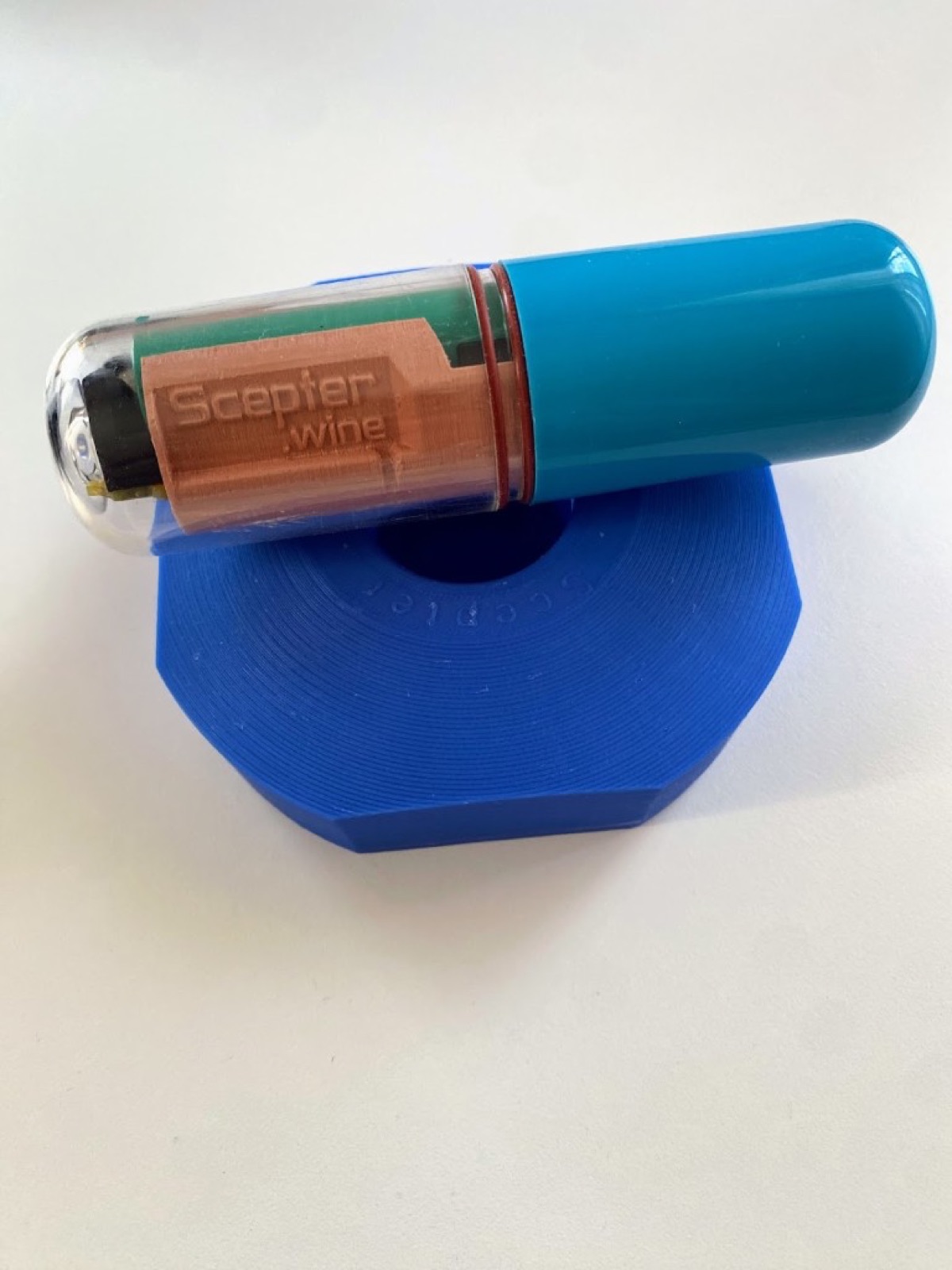 Blue SCEPTER float device resting on its wireless charging dock